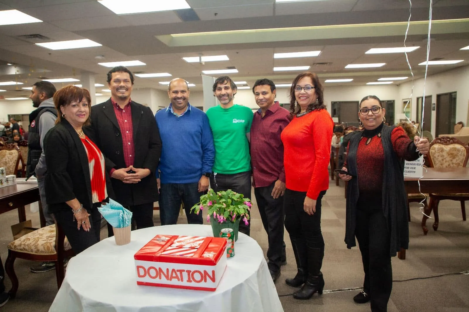 The One Love team together beside a donation box at Pepperpot Fest 2022