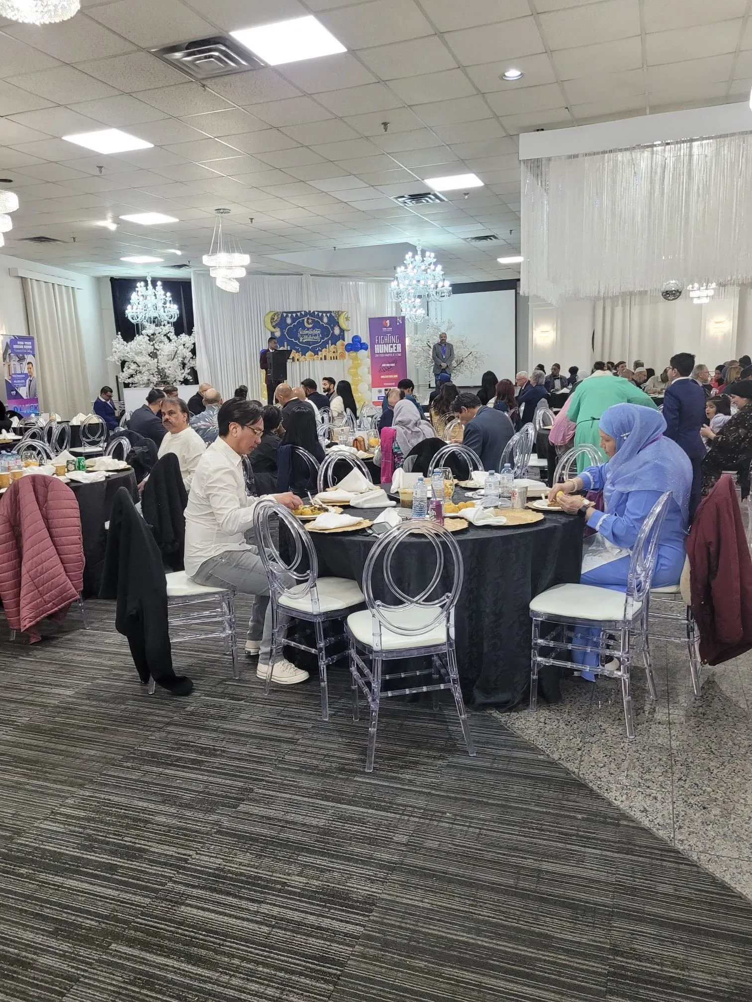 Guests seated at dinner tables in the banquet hall at the Ramadan interfaith dinner