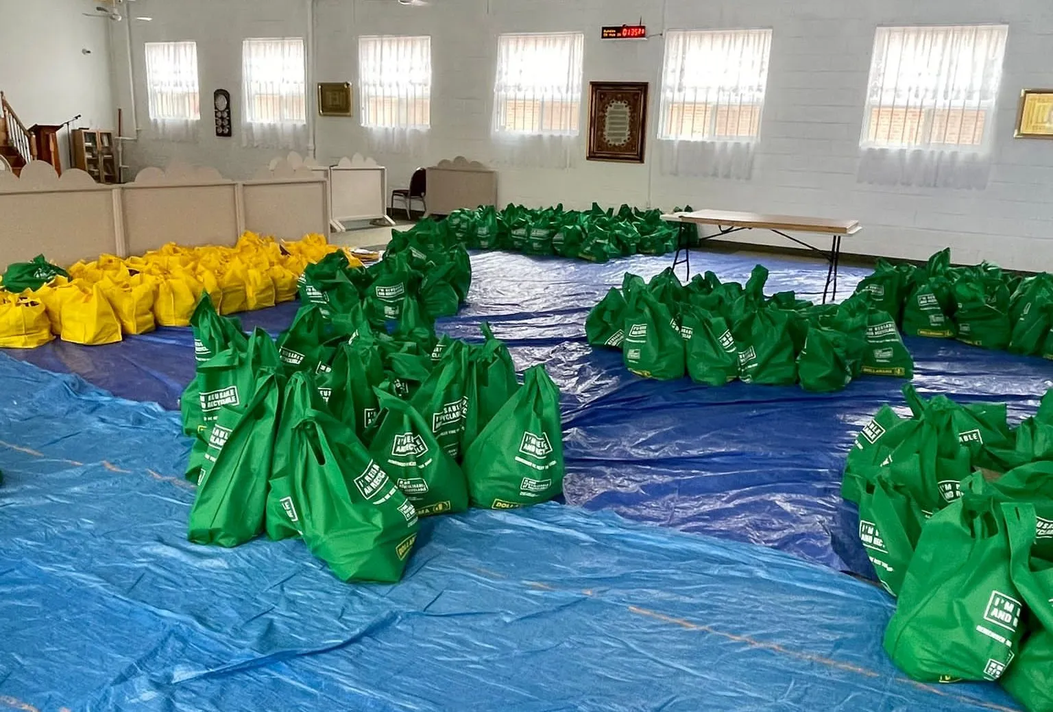 Rows of One Love Table hamper bags laid out in a hall, ready for distribution