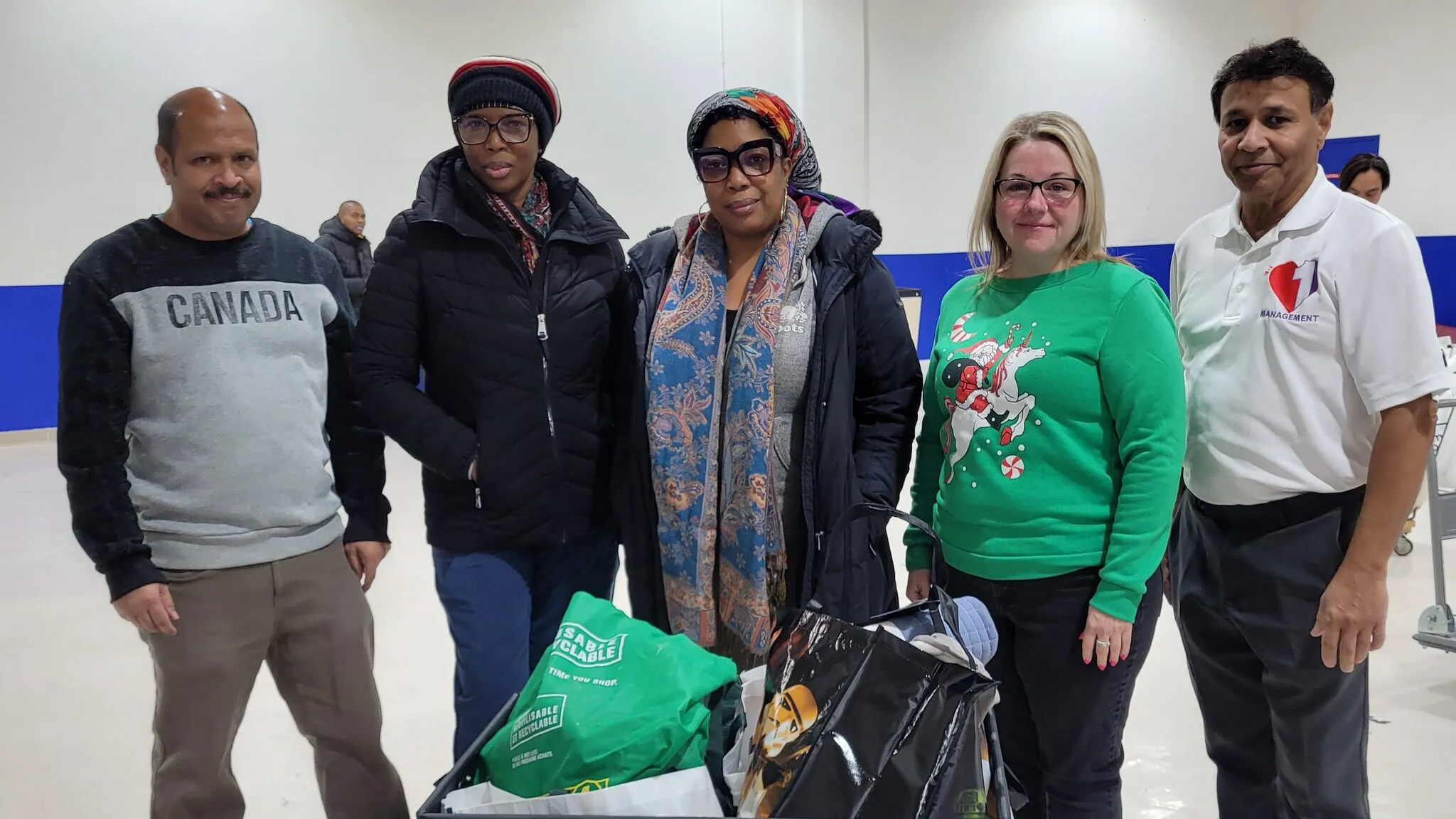 One Love volunteers standing around a cart of filled bags in the community hall